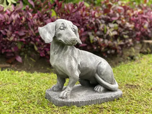 Product image of the product “Timber - Dachshund sitting on base, 35cm L | cast stone ”